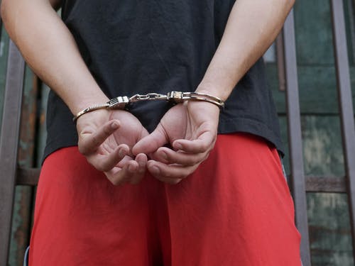 Picture of person in handcuffs, possibly after being arrested for a violation of probation, mail in probation, administrative probation, community control or supervised release.